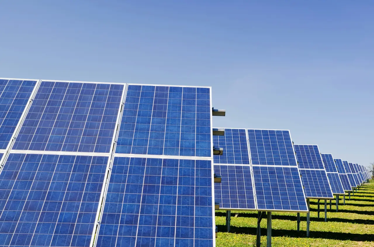 Painéis solares azuis em fileiras sob céu limpo